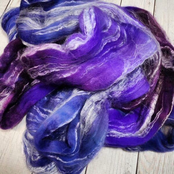 A pile of purple and blue flannel laying on a wooden floor.