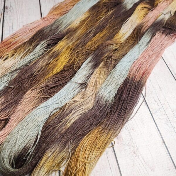 A skein of multicolored yarn on a wooden floor.